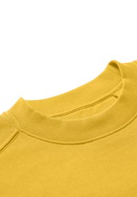 Camiseta de algodón amarilla con un cuello redondo acanalado. La tela es suave con costura plana cerca del cuello, mostrando un color sólido.