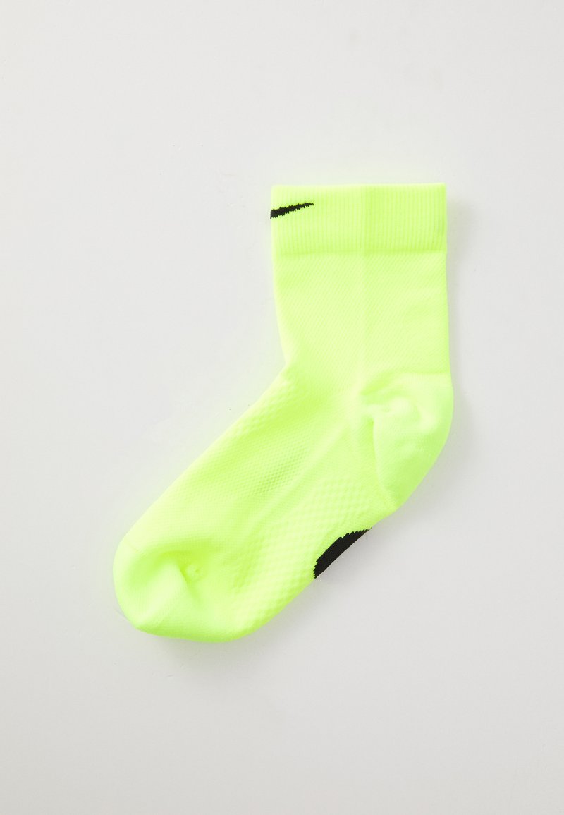 Neon yellow Nike ankle sock with black swoosh logos on cuff and sole, displayed flat on a white background.