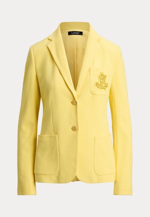 Κίτρινο γυναικείο σακάκι με δύο κουμπιά μπροστά, τρεις τσέπες συμπεριλαμβανομένης της κεντημένης τσέπης στο στήθος και γιακά με σταυρωτό πέτο.