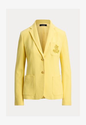 Κίτρινο γυναικείο σακάκι με δύο κουμπιά μπροστά, τρεις τσέπες συμπεριλαμβανομένης της κεντημένης τσέπης στο στήθος και γιακά με σταυρωτό πέτο.