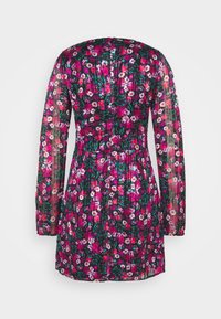 Robe courte à manches longues avec une taille cintrée, un tissu transparent et un motif floral vibrant rose, blanc et vert sur un fond foncé.