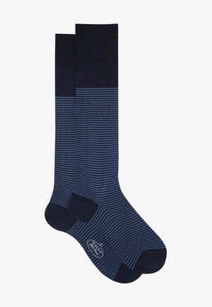 Calze al ginocchio con parte superiore a coste di colore blu navy e parte inferiore a strisce blu. Tessuto morbido con tallone e punta in un blu scuro a contrasto.