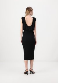 Black dress with a scoop back, fitted silhouette, and knee-length hem. Made of smooth fabric, with short sleeves and gathered detailing.