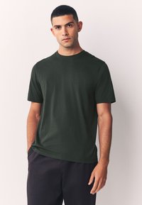 Sügavroheline lühikeste varrukatega t-särk pehmest kangast, ümara kaelusega, mugava lõike ja siledalt tekstuuriga.