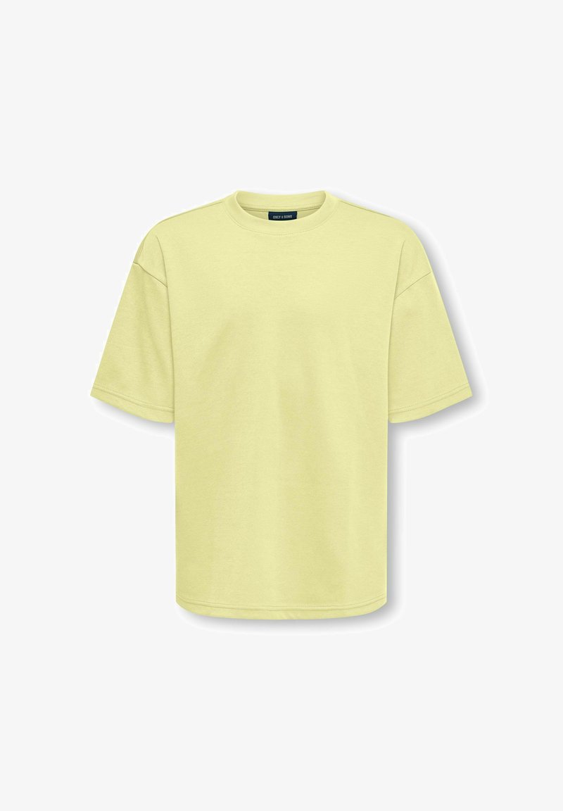 Ανοιχτόκίτρινη oversized βαμβακερή κοντομάνικη μπλούζα με στρογγυλή λαιμόκοψη, τοποθετημένη επίπεδη σε λευκό φόντο.