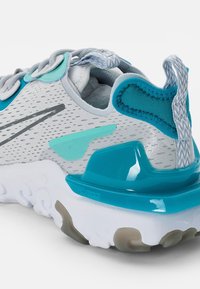 HERRLÖPARSKOR MED GRÅTT MESHOVANDEL, TURKOSA ACCENTER OCH EN GLANSIG TURKOS HÄL. HAR EN DÄMPAD VIT SULA OCH EN FLEXIBEL DESIGN.