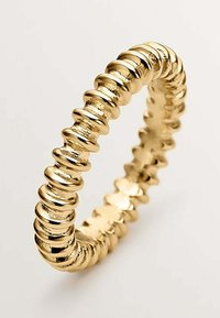 Anillo de oro con un diseño texturizado que presenta secciones alternas suaves y acanaladas, creando un patrón visualmente dinámico.