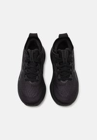 Black athletic shoes featuring a textured upper, lace closure, padded collar, and subtle logo accents. Flat rubber outsole for traction.
