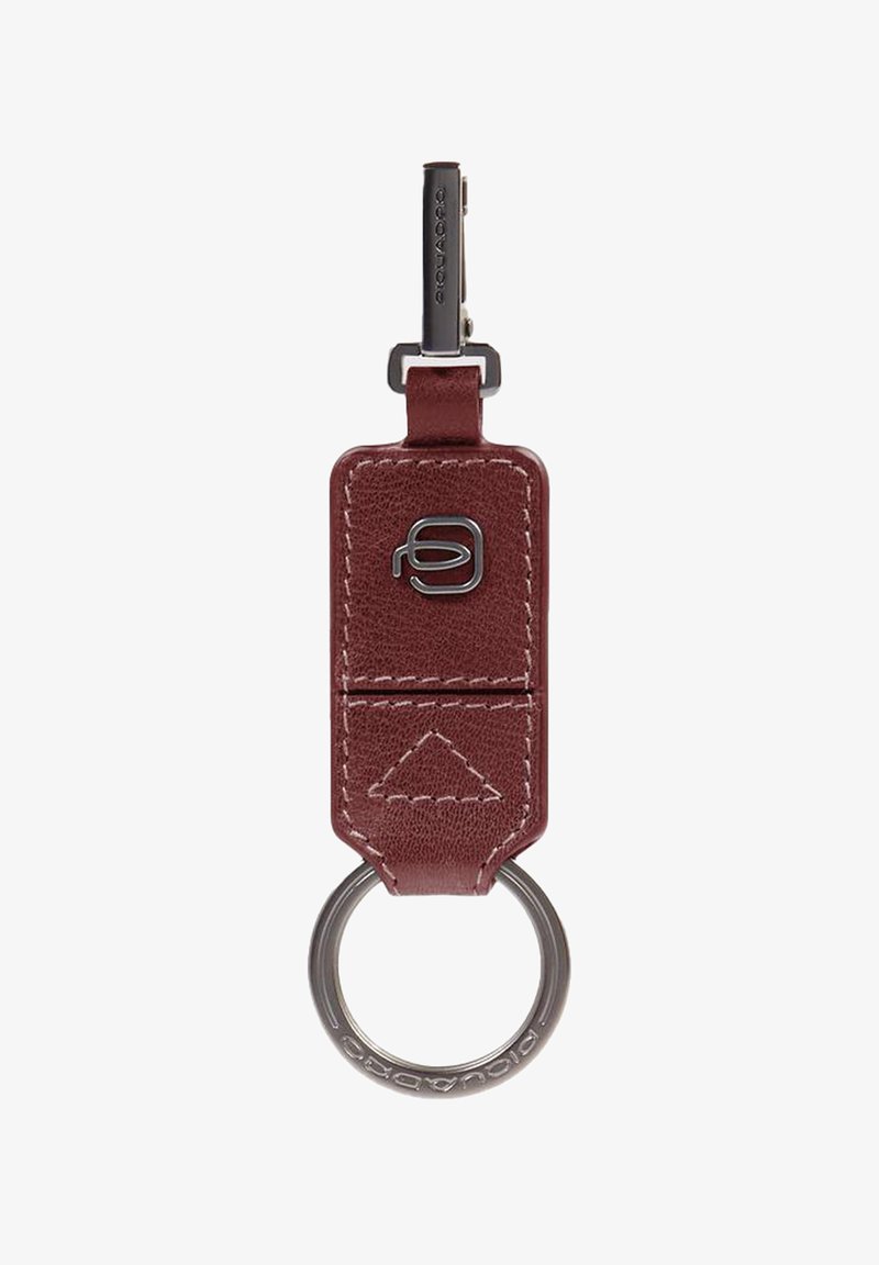 Llavero de cuero burdeos con un anillo metálico, que presenta un patrón de costura triangular y un logotipo prominente en la parte frontal.