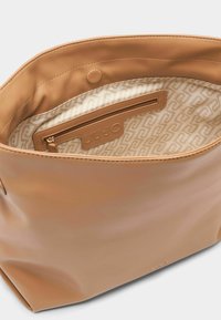 Borsa in similpelle liscia color cuoio con tasca interna con zip e fodera decorata con il logo del marchio. Accenti hardware discreti.