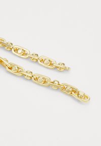 Armbanduhr aus goldfarbenem Metall mit ovalen Gliedern, runden Akzenten und einer polierten Oberfläche. Die Glieder sind mit kreisförmigen Elementen verbunden, um zusätzliche Details zu bieten.