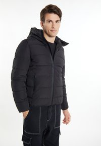 Jachetă puffer neagră cu închidere tip fermoar, glugă și cusături orizontale. Material moale, căptușit, completat cu buzunare laterale și manșoane elastice.
