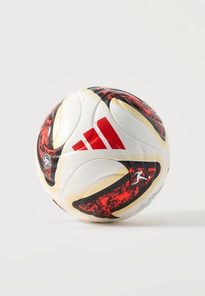 Ballon de football blanc avec des motifs rouges et noirs et un logo Adidas rouge sur un fond neutre.