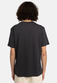 Schwarzes Baumwoll-T-Shirt mit kurzen Ärmeln, Rundhalsausschnitt und schlichter Gestaltung. Die Rückseite zeigt eine glatte Textur ohne Grafiken oder Akzente.