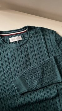 Dark teal knitted sweater with diamond pattern, crew neckline, long sleeves, and a label reading "PEER ONE" inside the collar.