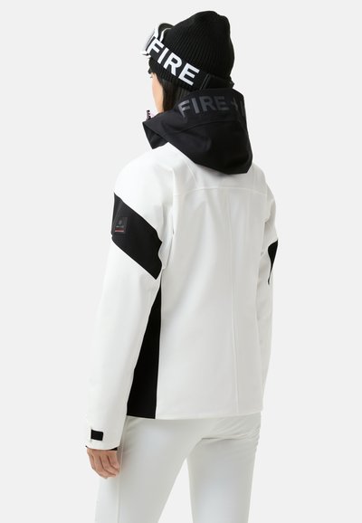 Hvid og sort vandtæt jakke med en indsnøret hætte, justerbare manchetter og logo detaljer. Har et slankt, moderne design og en glat overflade.