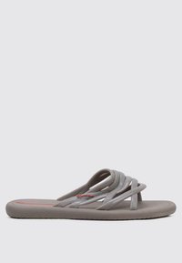 Sandalias grises con correas entrelazadas, fabricadas en material flexible. Presentan una plantilla texturizada y un logotipo sutil en rojo. Suela plana.