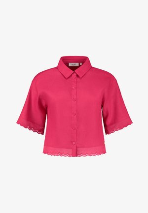 Blouse rose courte avec un col, fermeture à boutons à l'avant et bordure en dentelle festonnée aux manches et à l'ourlet. Fabriquée en tissu léger.