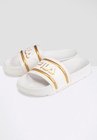 Sandales blanches avec des accents dorés, dotées d'une large sangle avec un logo en relief et d'une semelle intérieure texturée pour une meilleure adhérence. Design à semelle plate.