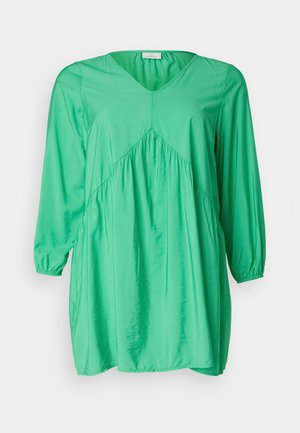 Groene tuniekjurk met een V-hals, lange poffende mouwen, geplooide details en een losse, vloeiende pasvorm; gemaakt van een gladde, lichte stof.