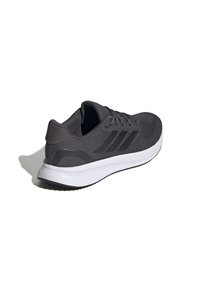 Zapatilla deportiva de color gris oscuro con un upper texturizado, tres rayas negras y una entresuela blanca. Cuenta con un cuello acolchado y suela de goma.