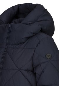 Marineblauwe gewatteerde jas met een hoge kraag, diagonale quiltontwerp, ritssluiting en een rond zwart logo-accent op de linkermouw.