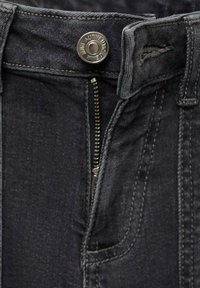 Temno sivi jeans iz denima imajo kovinsko zapiranje na gumb in zadrgo, s vidnimi šivi in majhnim sprednjim žepom.