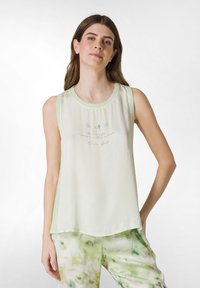 Lysegrønt ærmeløst top med rund halsudskæring, der har broderet tekst og finurlige designs. Det har en løs pasform og en glat struktur.