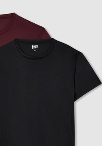 Czarne i burgundowe koszulki z krótkim rękawem, okrągłym dekoltem oraz nadrukowaną metką. Gładki materiał z minimalnymi szwami.