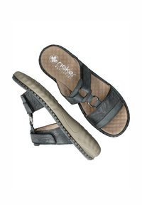 Zwarte leren sandalen met een gestructureerde binnenzool, verstelbare banden met metalen hardware en een flexibele beige rubberen zool.
