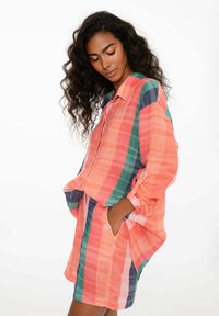 Karovaný kompletný set s košeľou a šortkami v koralovej, zelenej a námorníckej farbe. Vyrobené z ľahkého materiálu s rolovacími rukávmi a bočnými vreckami.