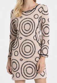 Vestido ajustado de manga larga en tela de color rosa claro con patrones circulares y de diamante en negro, que presenta un escote redondo y un acabado texturizado.