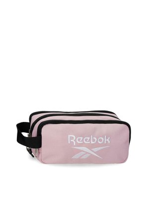 Bolsa rectangular de color rosa claro de Reebok con tres compartimentos con cremallera y un asa lateral negra.