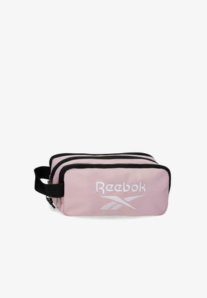 Bolsa rectangular de color rosa claro de Reebok con tres compartimentos con cremallera y un asa lateral negra.