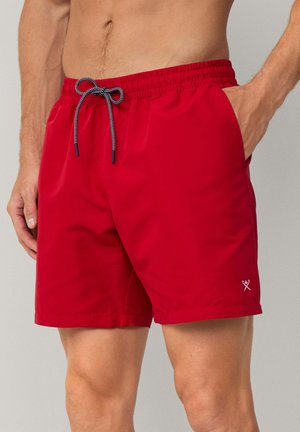 Rote Badeshorts aus leichtem Material, mit einem elastischen Bund und einem schwarz-weißen Kordelzug sowie seitlichen Taschen.