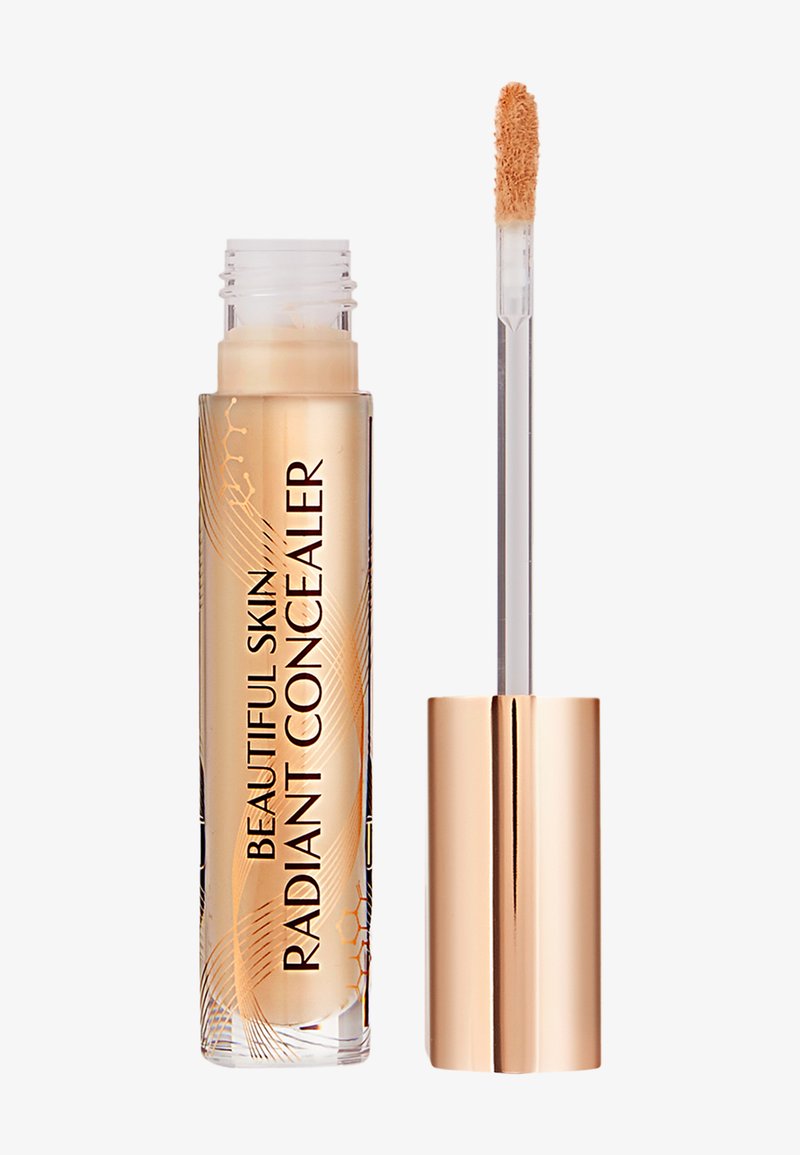Radiant concealer in a transparent tube with gold accents and a doe-foot applicator. The liquid is a light beige color with a smooth texture.