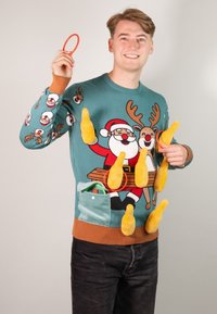 Weihnachts-Pullover in Petrol mit Motiv von Santa und einem Rentier. Enthält kuschelige gelbe Flaschen und bunte Ringe. Braun abgesetzte Bündchen und Taschendetails.