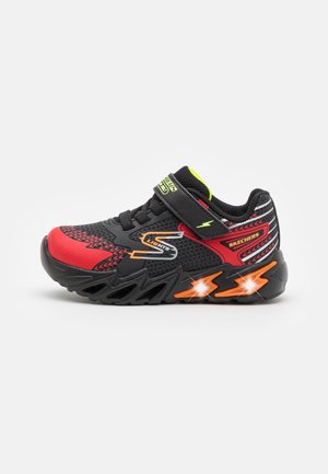 Baskets Skechers pour enfants noires, rouges et orange avec semelle lumineuse, strap velcro et design éclair sur le côté et la semelle.