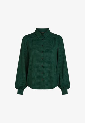Groene blouse met een kraag, lange pofmouwen en een knoopsluiting aan de voorkant, bezaaid met zwarte stippen en van textuurstof.