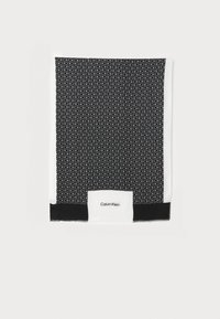 Black and white silk scarf featuring a repeating monogram pattern. Finished edges with a white border and a black accent at the bottom.