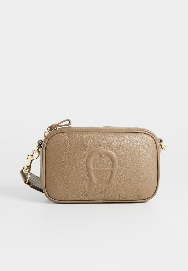 Kompakte beige Leder-Crossbody-Tasche mit geprägtem Logo auf der Vorderseite, goldfarbener Hardware und verstellbarem Trageriemen auf weißem Hintergrund.