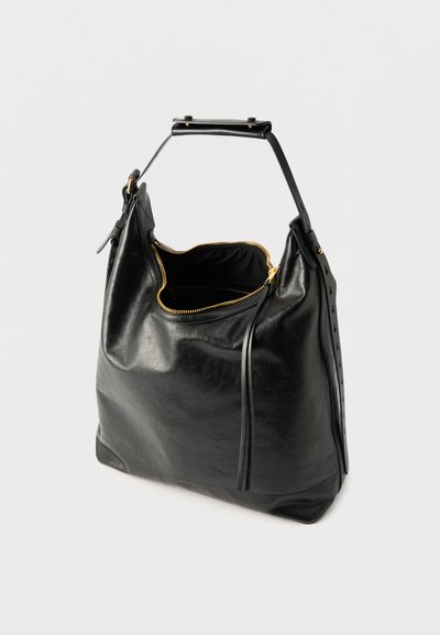 Μαύρη δερμάτινη τσάντα ώμου με φαρδιά ταινία, χρυστό φερμουάρ μερικώς ανοιχτό που αποκαλύπτει το σκοτεινό εσωτερικό και λεπτομέρειες από ραφές.