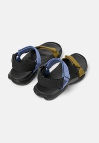 Sandals with a black rubber sole, featuring blue and olive green textile straps. Design includes adjustable Velcro closures and textured footbed.