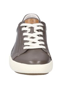 Ruskea nahkakengät valkoisilla nauhoilla ja kumipohjalla. Ominaisuuksia ovat pyöreä kärki ja vaaleanruskea yksityiskohta kielessä, jossa on merkintä "J.S."