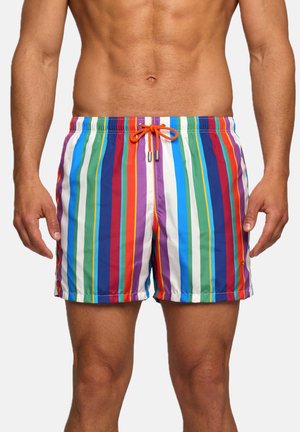 Uomo che indossa costumi da bagno colorati a righe verticali rosse, verdi, blu, viola e bianche, con coulisse arancione in vita.