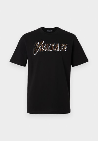 Melna kokvilnas t-kreklu ar īsām piedurknēm un apaļu kakla izgriezumu. Priekšpusē ir teksturēts, daudzkrāsains "VERSACE" logos.