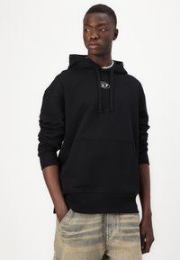 Sweatshirt à capuche noir en mélange de coton, doté d'une poche kangourou, d'un cordon de serrage et d'un logo discret sur la poitrine.