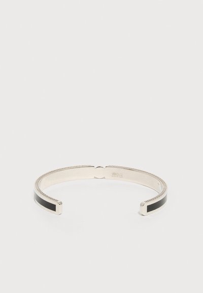 Ασημί βραχιόλι ανοιχτού τύπου με μαύρες ένθετες λεπτομέρειες και χαραγμένο μοτίβο ελληνικού κλειδιού κατά μήκος των άκρων, με την επωνυμία "Versace Made in Italy" στο εσωτερικό.