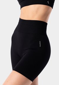 High-waisted black athletic shorts made of stretchy fabric, featuring a smooth texture and a small logo detail on the side.