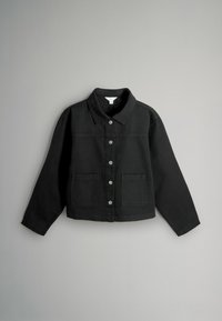 Melna denima jaka ar pogām priekšpusē, divām priekšējām kabatām un klasisku apkakli. Tam ir apgriezts dizains un garas piedurknes.